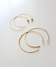 "Our Maya Open Hoop earrings are weightless and versatile for your daily style. Handcrafted from 14k Gold Filled wire, the hammered texture reflects light from all sides. Easy open hoop design adds a modern update to your everyday hoop. Choose from 1.75\" or 2\" sizing and either Thin 20 gauge style with gold earring backs, or Thicker 18 gauge style with clear earring backs. Please note the 18 gauge option is thicker than typical ear wire, so if you have sensitive ears, you may want to choose th Hoop Earrings Large, Boho Hoop Earrings, Clear Earrings, Hammered Hoop Earrings, Open Hoop Earrings, Gold Filled Hoops, Earrings Large, Hammered Gold, Gold Filled Earrings