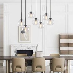 a dining room table with chairs and lights hanging from it's centerpieces