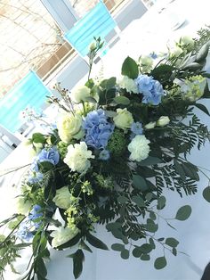 a bouquet of blue and white flowers sitting on top of a table