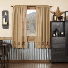 a living room filled with furniture and a window covered in star curtain valances