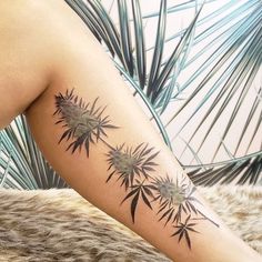 a woman's leg with tattoos on it and palm trees in the back ground