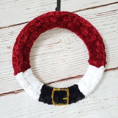 a red and white wreath with a santa hat on it