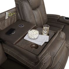 the reclining chair has a tray with popcorn and drinks on it