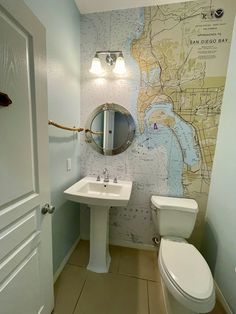 a bathroom with a map on the wall next to a toilet and sink in it