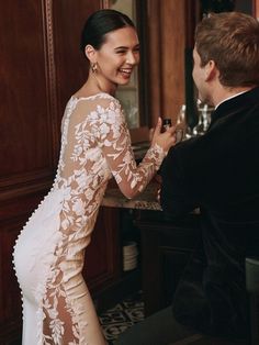 a woman in a white dress standing next to a man