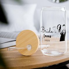 a clear glass vase with a bride and groom photo on the front, next to a wooden paddle