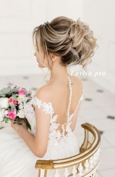 a woman in a wedding dress sitting on a chair with flowers and pearls around her neck