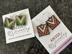 two pairs of beaded earrings sitting on top of a card next to each other