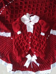 a red knitted sweater with white lace trims and bows on the collarline