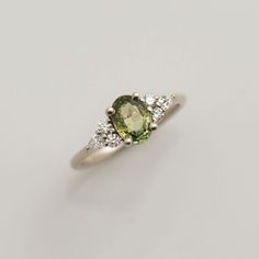 an oval shaped green and white diamond ring