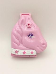 a pink plastic toy horse with stars on it's head and eye painted on its forehead