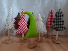 small wooden trees are lined up on the floor in front of a white wall with polka dots