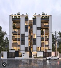 an apartment building with balconies and plants on the top floor, next to a parking lot