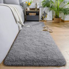 a bedroom with a large gray rug on the floor next to a bed and nightstand