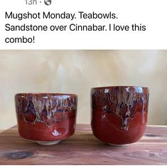 two mugs sitting on top of a wooden table next to each other with words written below them