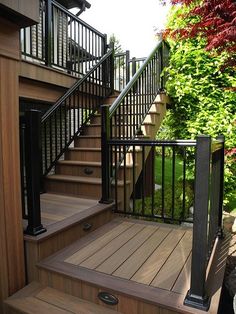 a wooden deck with black railing and handrails