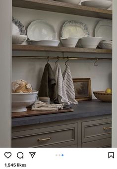 the shelves in this kitchen are filled with plates and bowls, dishes on top of them