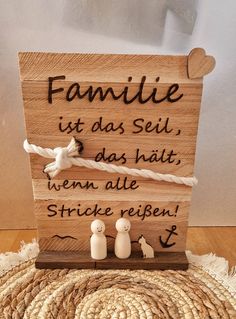 a wooden sign with two small white dolls on it