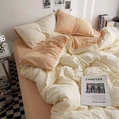 an unmade bed with a book on it