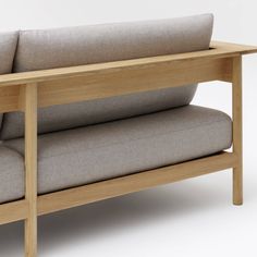 a wooden bench with two cushions on it's sides and one arm folded back to the side