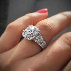 a woman's hand holding an engagement ring with two rows of diamonds on it