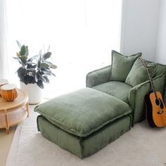 a living room with a green couch and guitar