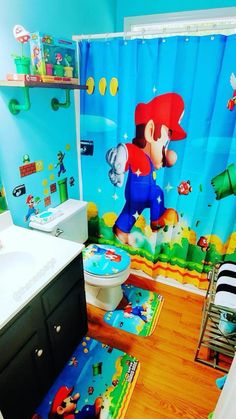 a bathroom decorated in mario bros theme with toilet, sink and shower curtain is shown