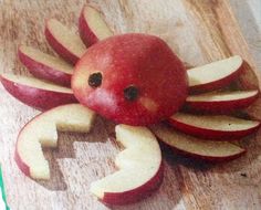 an apple shaped like a crab on top of a cutting board