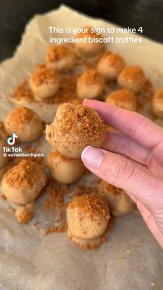 someone is holding their finger up to some food on a piece of parchment paper with the words, this is your sign to make 4 ingredient biscuit truffles