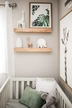 a baby's room with two shelves above the crib and a stuffed animal