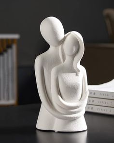 a white sculpture sitting on top of a table next to a stack of bookends