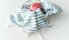 an apple is wrapped in a green and white striped towel