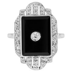 A stunning, fine and impressive Art Deco style diamond and onyx halo ring. A total of 0.058 carats of diamond are set in square shaped onyx. A stunning piece to match with your everyday look. Ring Information Style: Art-deco Metal: 14K White Gold Weight: 4.30 g. (approx. total weight) Center Gemstones Type: Diamond Shape: Round Average Color: H Average Clarity: SI Size: 2.3 mm. Number: 1 Weight: 0.058 Carat (approx. total weight) Accent Gemstones Type: Onyx Shape: Square Number: 1 Accent Gemston Impressive Art, Dinner Ring, Estilo Art Deco, Halo Ring, Halo Rings, Art Deco Style, Ring Box, Deco Style, Cocktail Rings