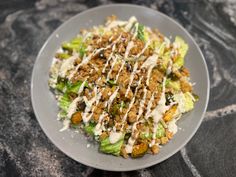 a white plate topped with lettuce covered in dressing