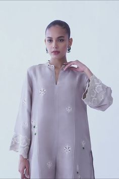 A beautifully crafted silver rawsilk fabric with floral eyelet detailing and embroidered sleeves. The look is completed with matching co-ord izaar with embroidered hem. Elegant Unstitched Kurta With Embroidered Sleeves, Elegant Floral Embroidered Raw Silk Set, Elegant Sets With Floral Embroidery In Raw Silk, Elegant Sets With Floral Embroidery On Raw Silk, Traditional Spring Kurta With Set-in Sleeves, Elegant Chikankari Embroidered Top For Wedding, Elegant Embroidered Sleeves Kurta For Eid, Spring Festive Kurta With Set-in Sleeves, Elegant Floral Embroidery Sets For Festive Occasions