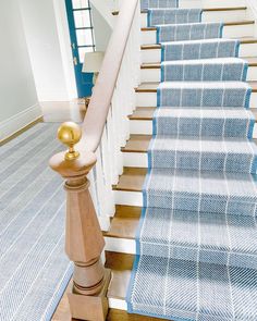 a blue and white carpeted staircase leading up to the second floor