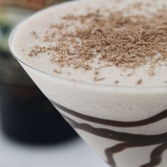 a close up of a drink in a glass with chocolate sprinkles on top