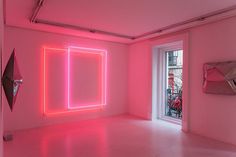 an empty room with pink walls and neon lights