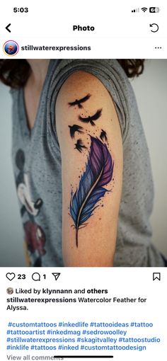 a woman's arm with an inked feather and birds flying over her shoulder