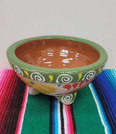 a bowl sitting on top of a colorful table cloth