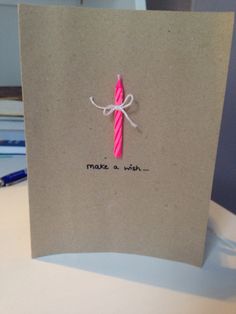 a brown card with a pink candle on it