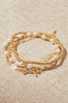 18K Gold Beaded Bow Bracelet Pack in Gold | Altar'd State Birkenstock Clogs, Beaded Bow, Pretty Jewelry Necklaces, Bracelet Pack, Bow Bracelet, Jewelry Accessories Ideas, Jewelry Essentials