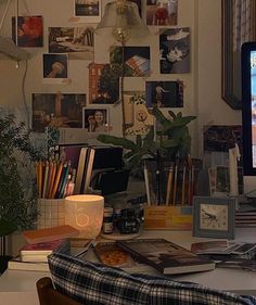 a computer monitor sitting on top of a desk in front of a wall covered with pictures