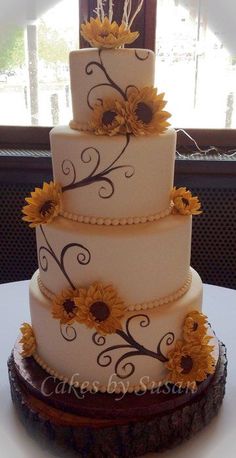 a three tiered cake with sunflowers on it