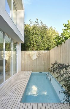 an empty swimming pool next to a wooden deck