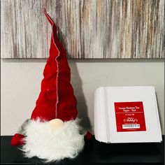 a red and white santa hat sitting next to a box