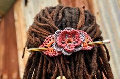 a close up of a person with dreadlocks and a crochet flower