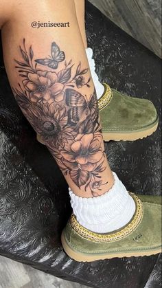 a woman's leg with flowers and butterflies on it