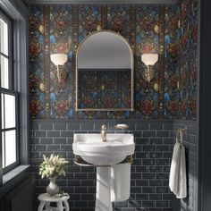 a white sink sitting under a bathroom mirror next to a window with a vase on it