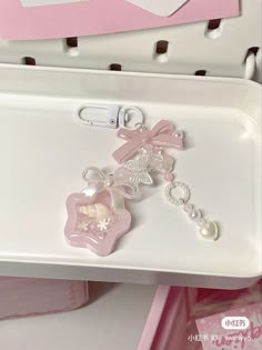 a white tray with some pink and white items on it's side, sitting next to a pair of scissors